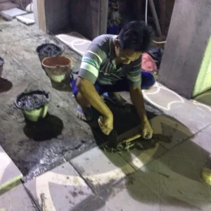 pemasangan tegel pada rumah pelangga